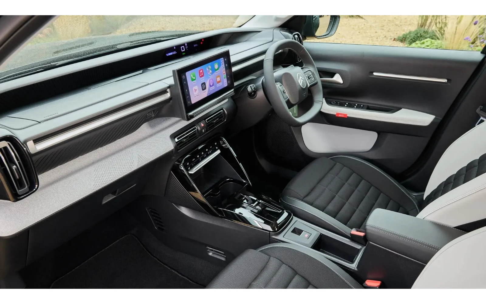 Interior view of a black and white Citroen C3 Aircross with a central touchscreen and textured dashboard.
