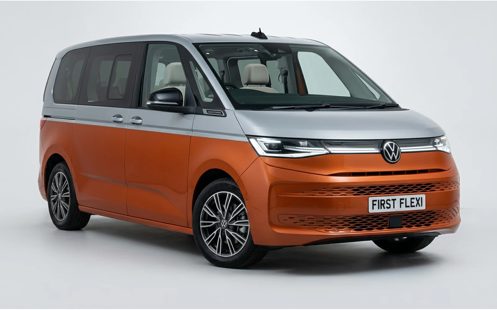 Orange and silver Volkswagen Multivan viewed from the front left.