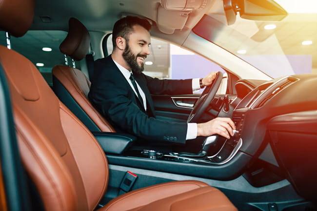 man sitting in a leased car