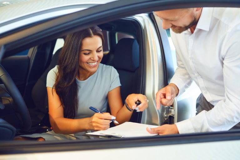 young woman buys a car in a car showroom