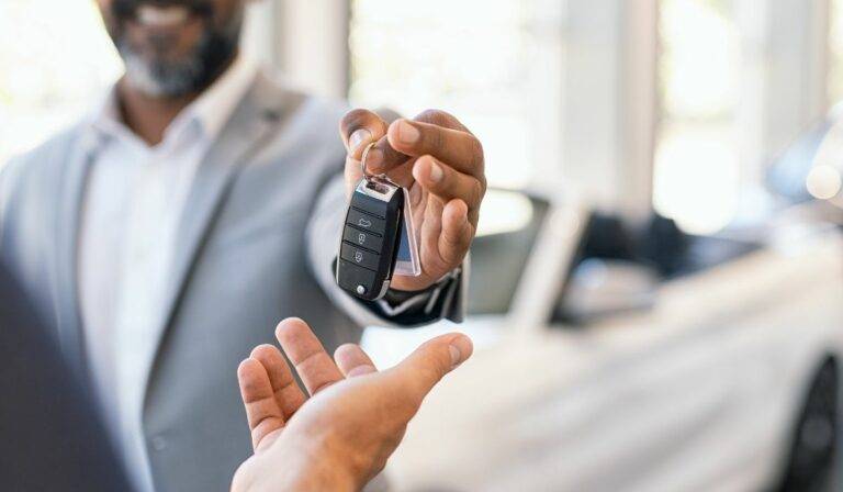 man handing over car key in sale