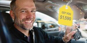 Man happily holding car keys with a price tag.